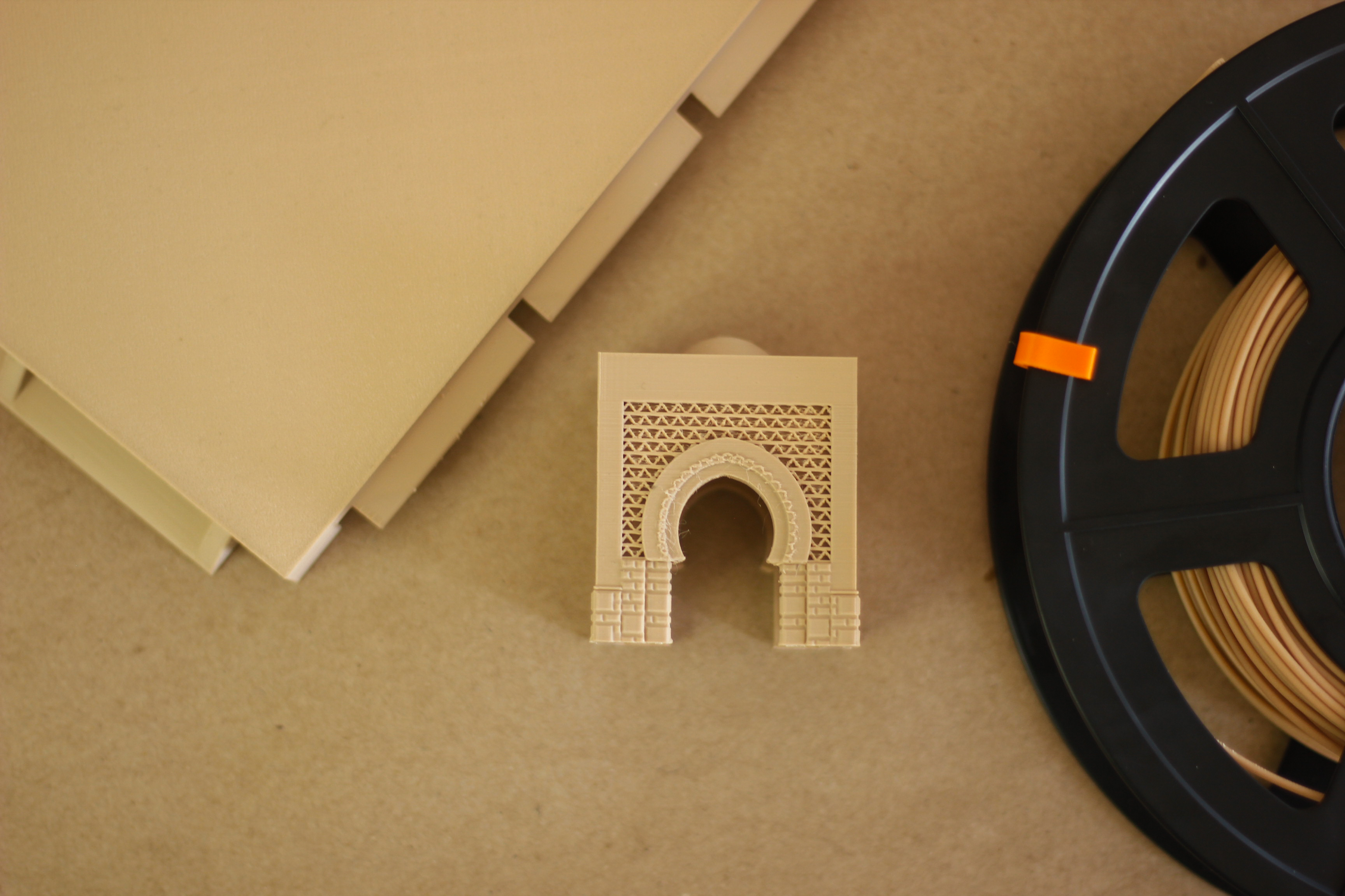 A printed gate beside a spool of wood-filled biocomposite filament