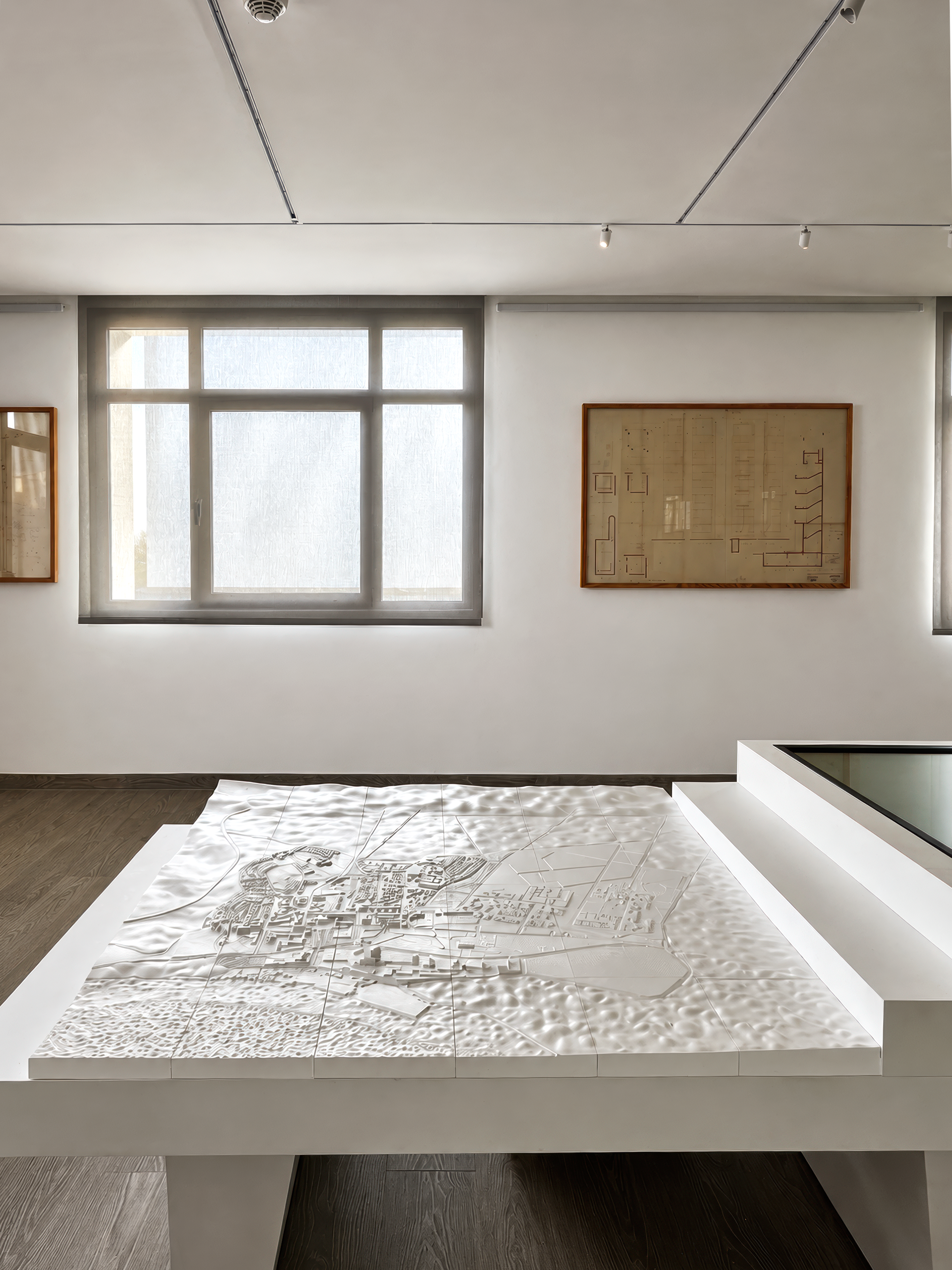 Exhibition room with the printed city-terrain model and archival drawings
