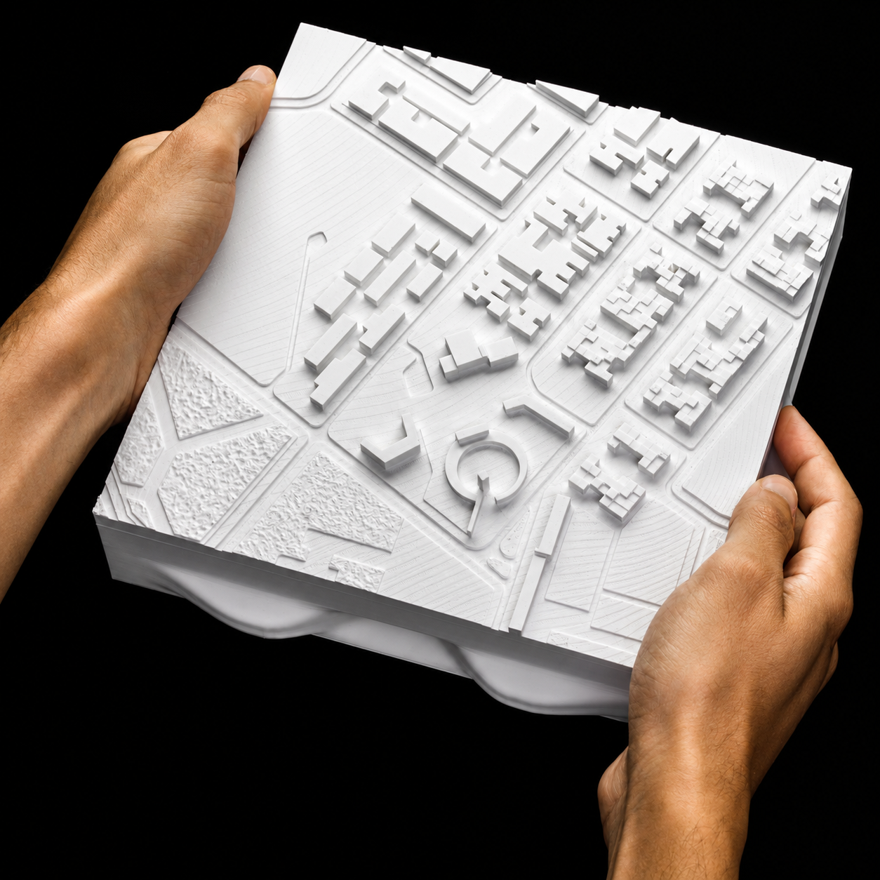 A demountable printed block of the city plan, held in two hands